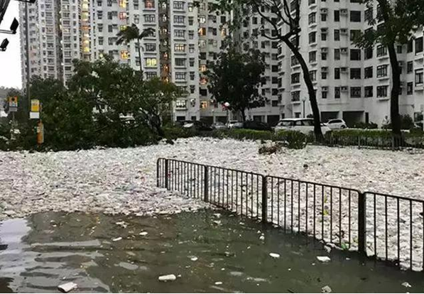 大量垃圾漂浮在還未退去的積水上,包圍了居民大樓